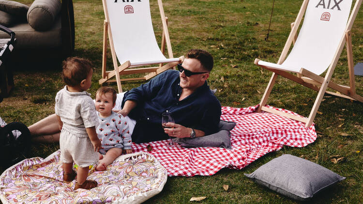 man on picnic blanket with kids