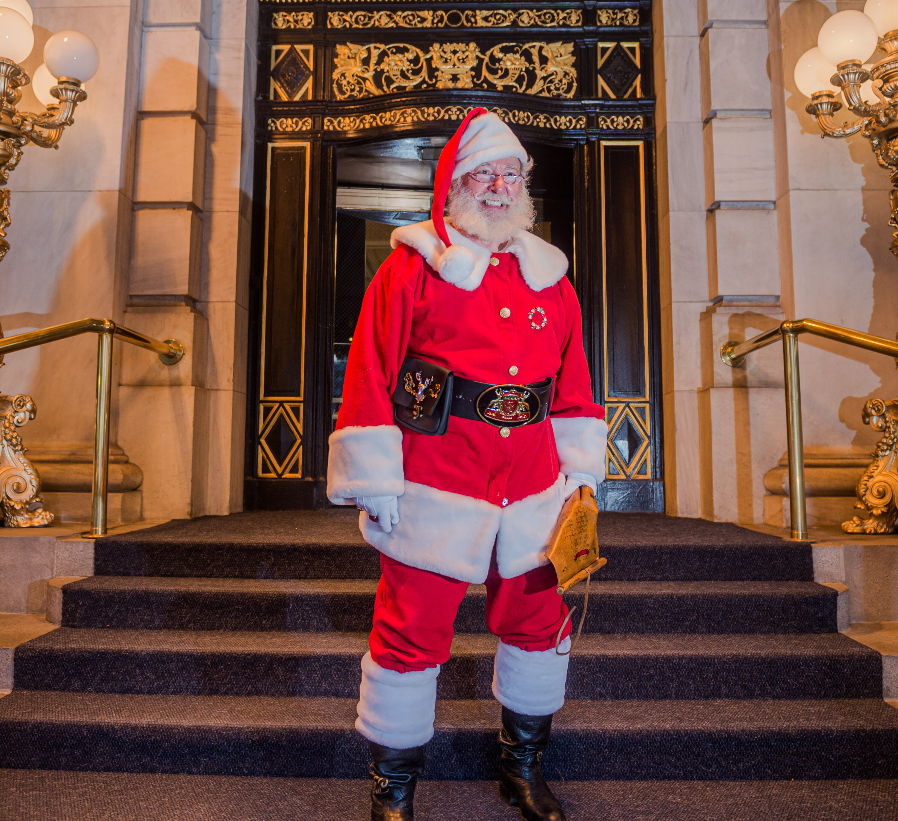 Santa poses for a photo outside of The Plaza Hotel.