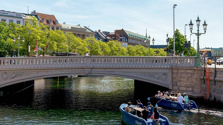 A,Boat,With,People,Is,Sailing,Along,A,Water,Canal