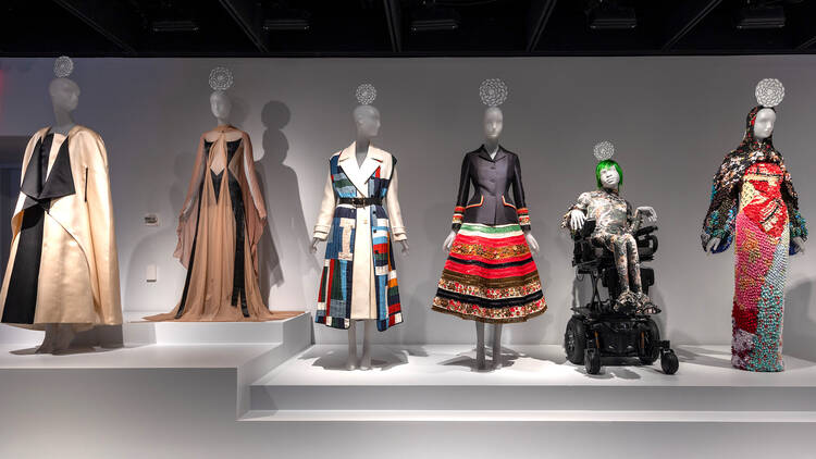 A wall of mannequins wearing fashionable clothing.