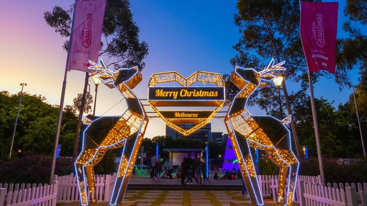 Christmas decorations over a path. The sign says: Merry Christmas 