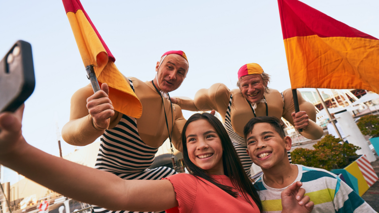 Kids taking a selfie with life guard circus men