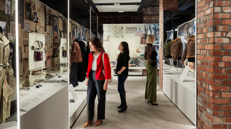 Women look at an exhibition of military inspired fashion