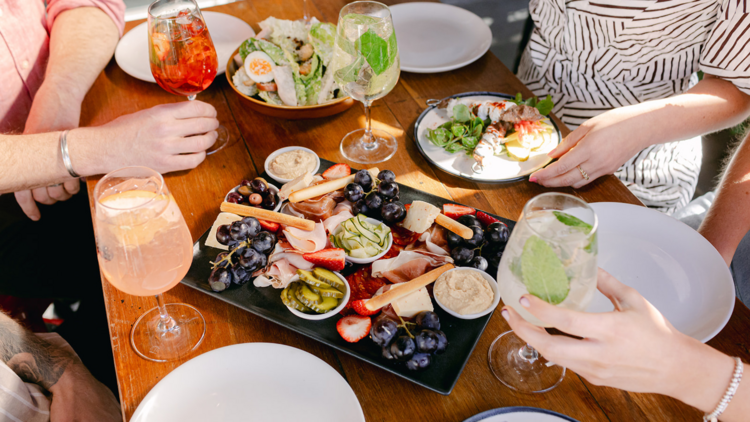 A spread of charcuterie, Caesar salad and spritzes from above