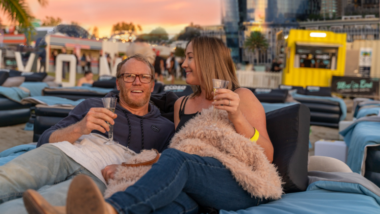 A couple at an outdoor beach cinema with champange