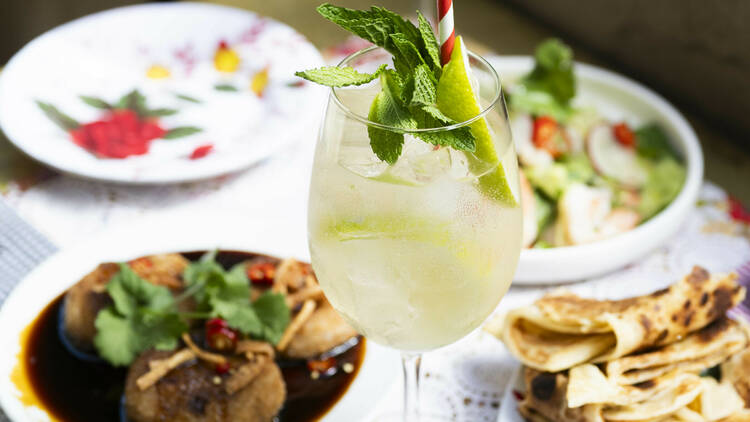 Table of Thai-inspired dishes and a Spritz cocktail.