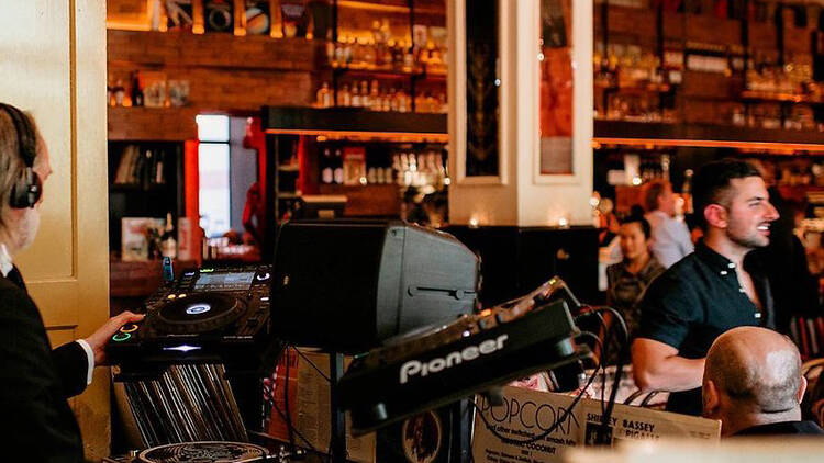 DJ playing music to a crowded beer hall.