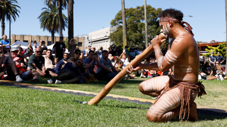 Man plays the didgeridoo on St Kilda Foreshore