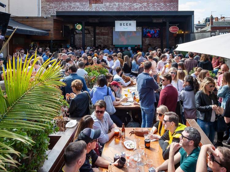 Crowded leafy beer garden.