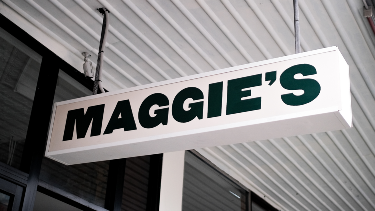 A black and white sign that says 'Maggie's'.