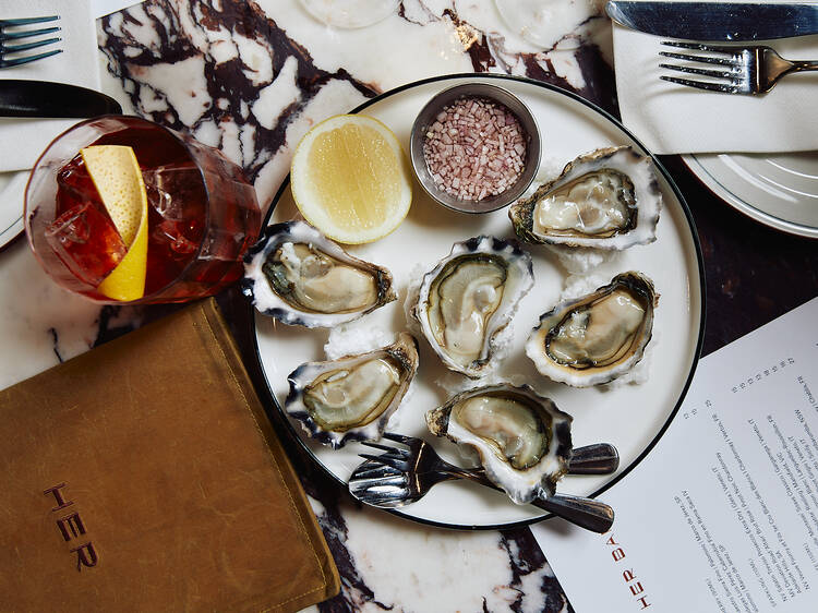 A plate of oysters on a marble table.