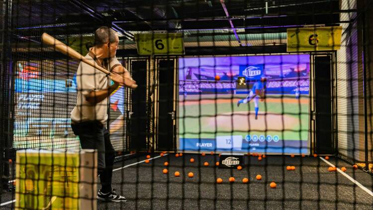 A man playing simulated indoor baseball
