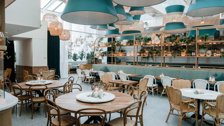 A restaurant with turquoise decor and big light shades.