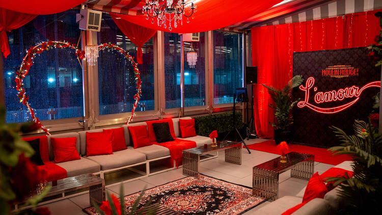 A Moulin Rouge pop-up with red curtains and decor.