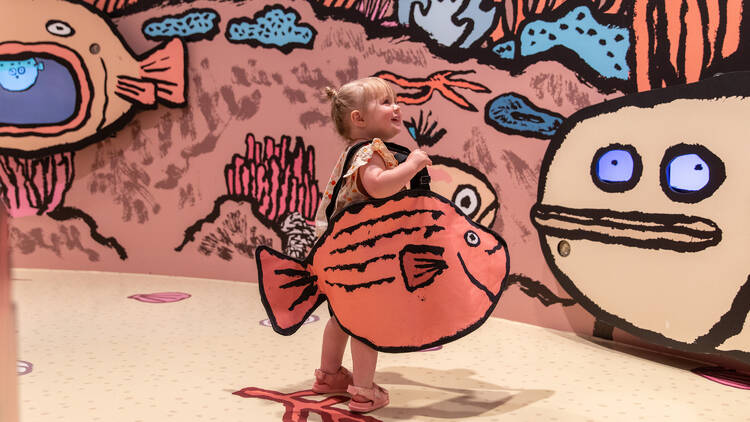 A child playing inside an ocean-themed art exhibition. 