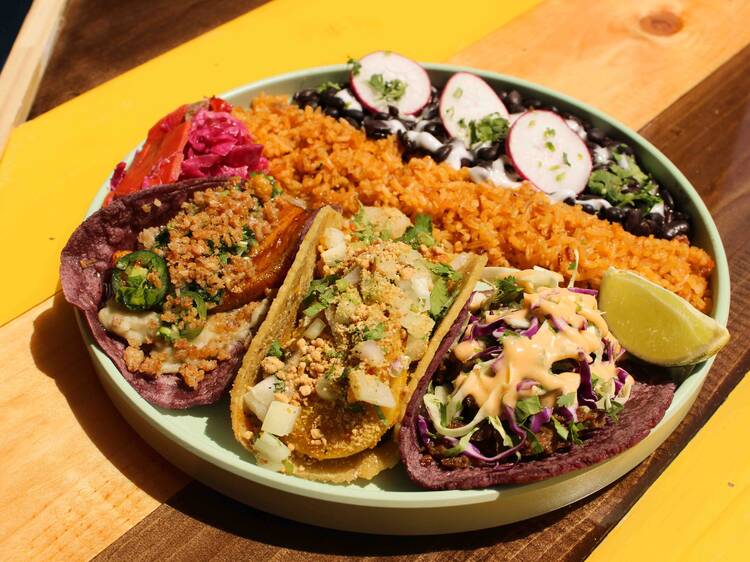 A plate of tacos, rice and beans