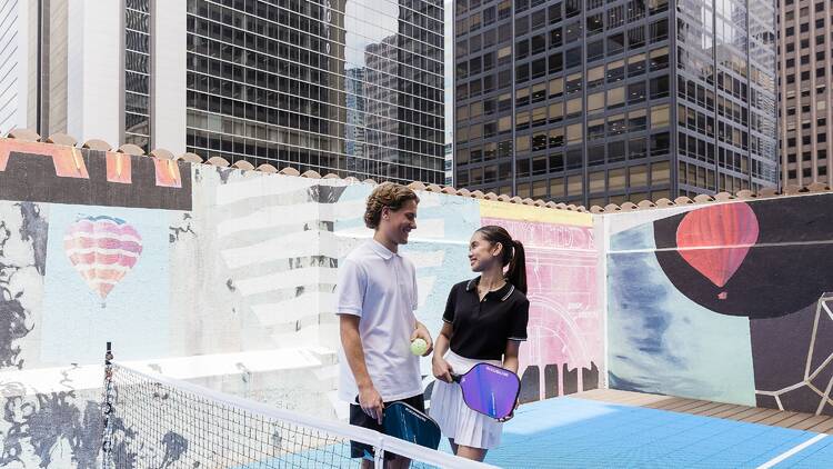 Two people on a pickleball court.