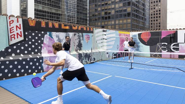 Four people playing pickleball. 