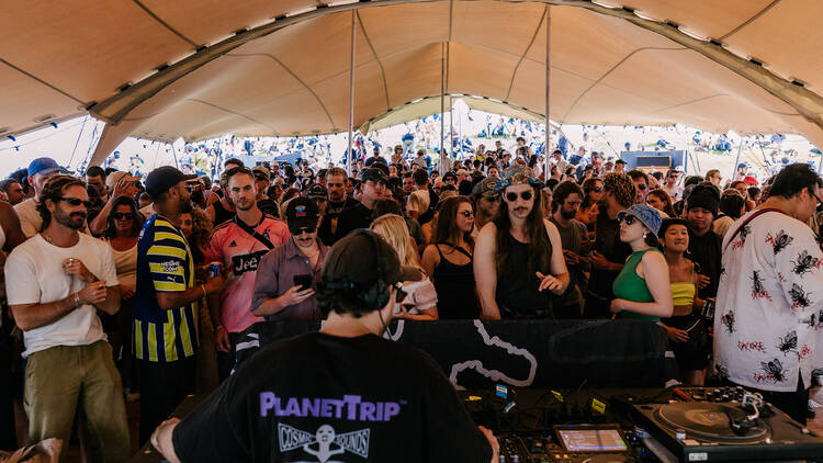A crowd listening to a DJ perform. 