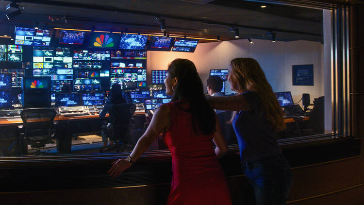 Two women look into the control room of NBC studios.