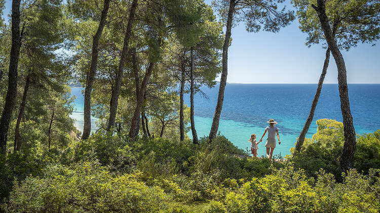 A woman and child walk in a forrest in the Sani Resort, Greece