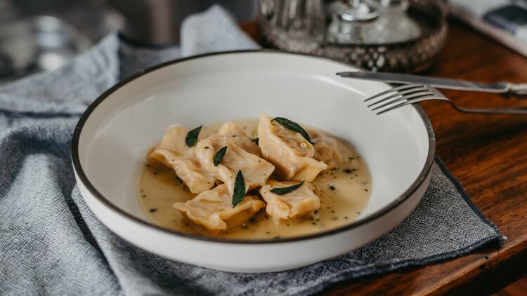 Agnolotti with sauce and herbs.