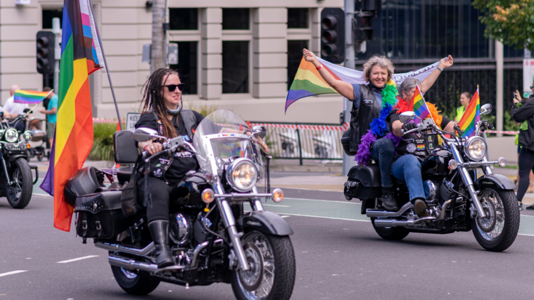 Members of the Dykes on Bikes ride motorbikes with rainbow flags and feathers