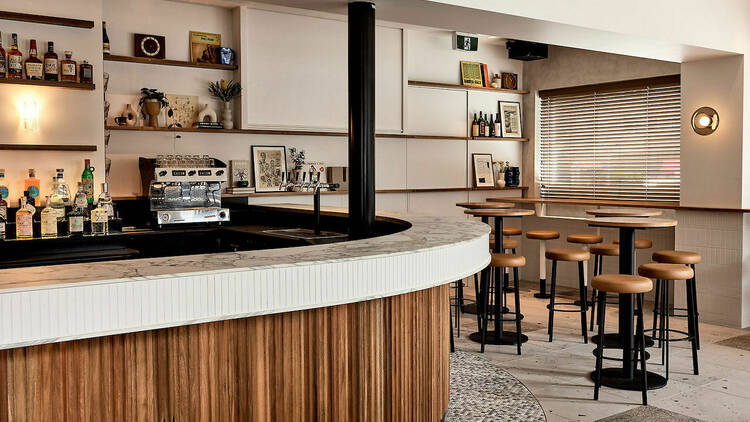 Wood-panelled bar and stools.