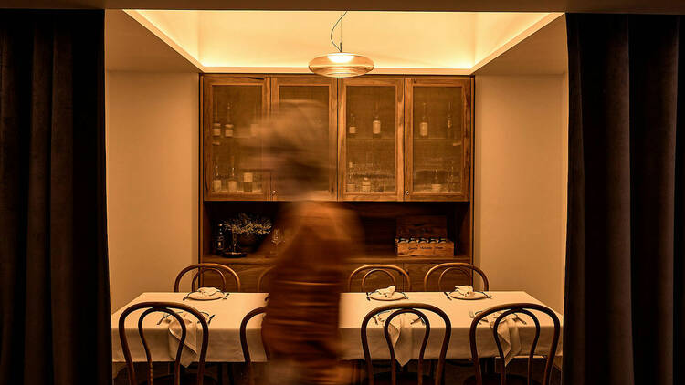 Person walking through an elegant private dining room. 