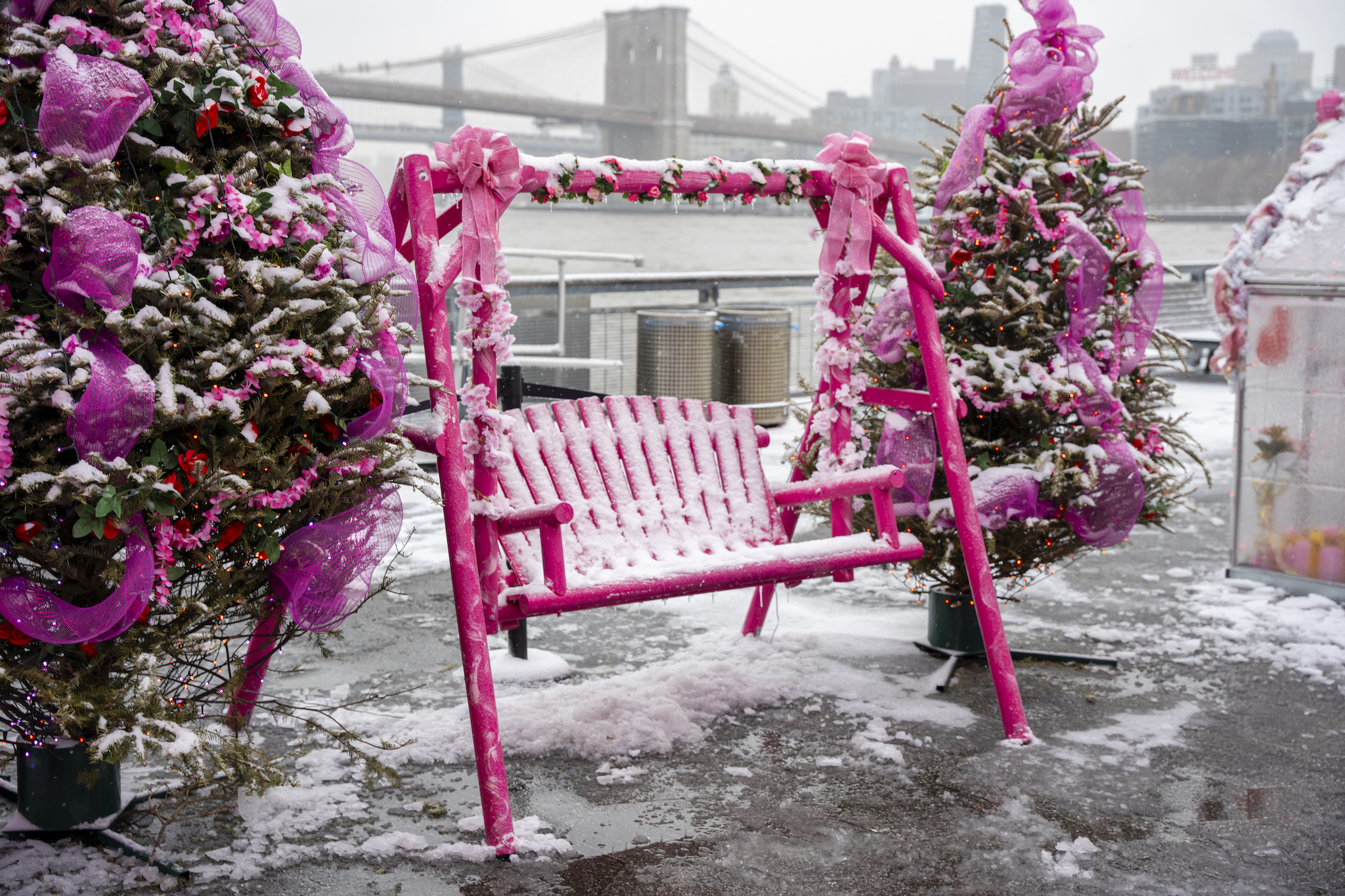 A pink bench covered in snow.