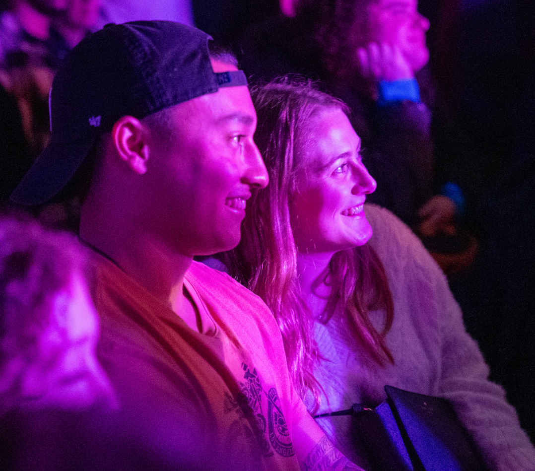 Two people laugh during a comedy show.