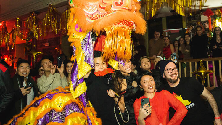 A crowd of people under a Chinese dragon dancer