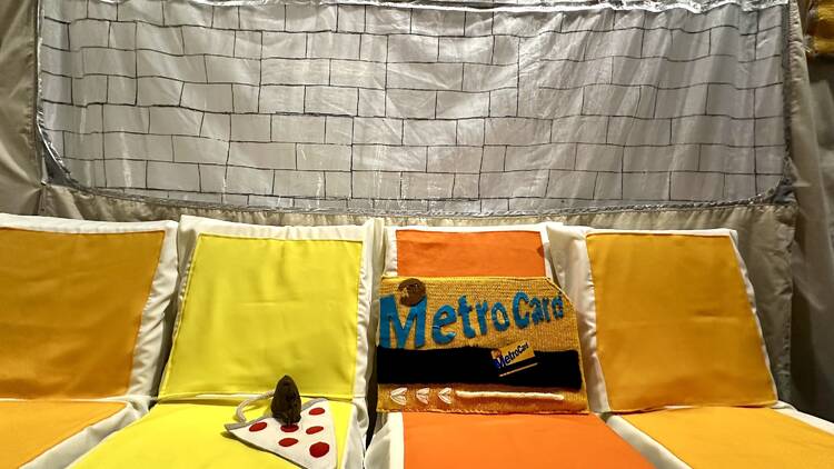 A fabric version of the NYC subway with a pizza rat and MetroCard.