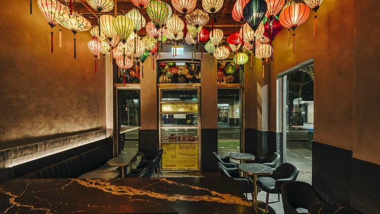 A dark bar with lanterns hanging from the ceiling