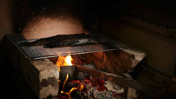 Fish getting cooked over an open flame at Yana