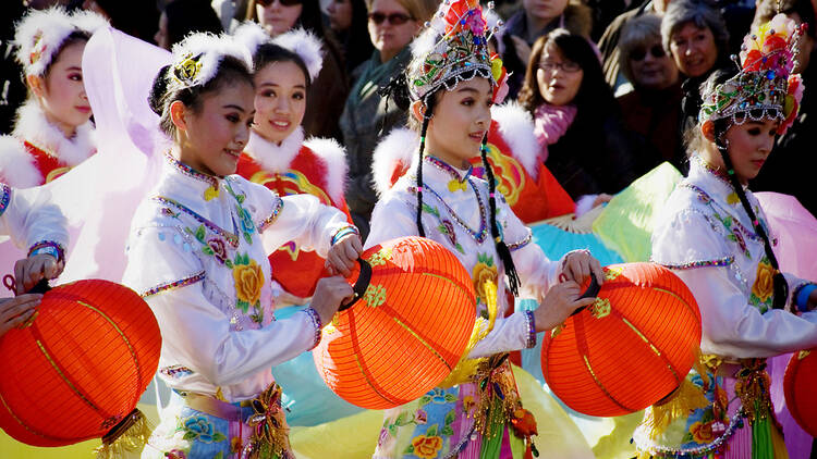 Women in traditional costume carrying lanterns at the London Chinese New Year parade