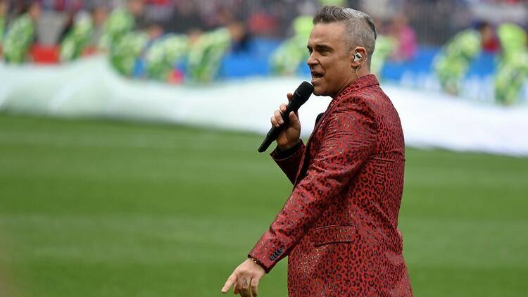 Robbie Williams performing on a football pitch