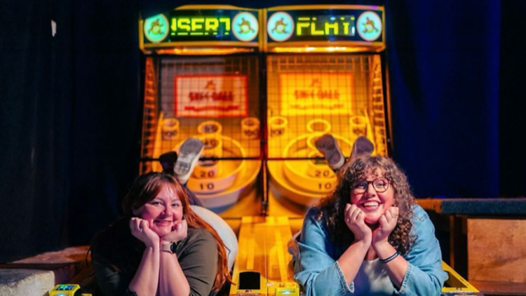 Two people lay on an arcade game