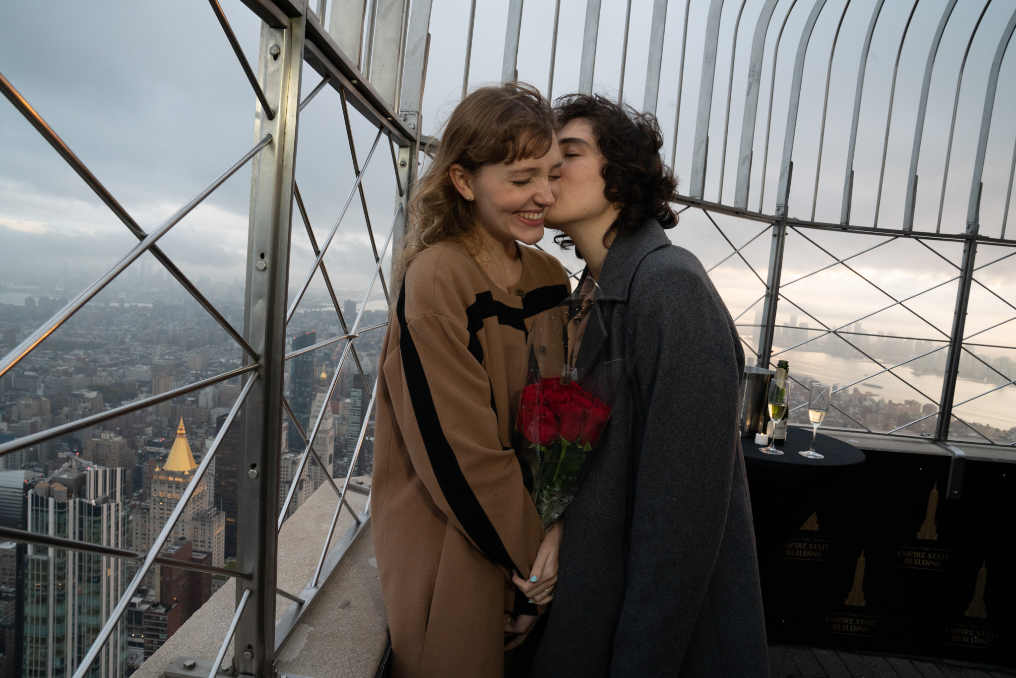 A couple snuggles atop the Empire State Building.