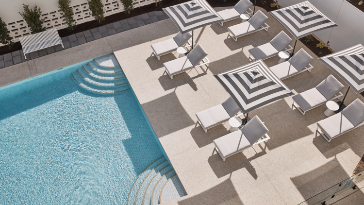 An outdoor pool with deck chairs and umbrellas