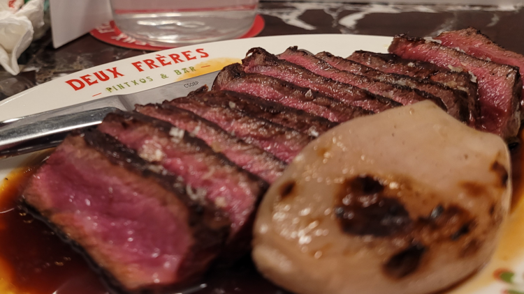 Rare beef sliced on a plate that says: DEUX FRERES