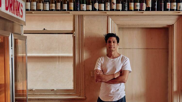 Pizzaiolo Kitisak Iacuzi posing for the camera in front of a wine shelf at Bahama Gold. 