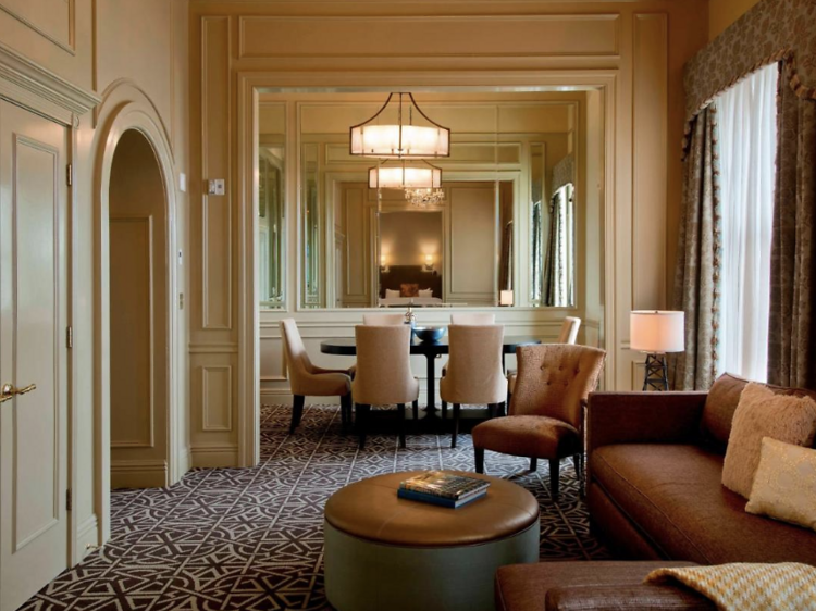 Suite at  Hotel Icon Houston with a sitting area and dining table with chairs in the  foreground.