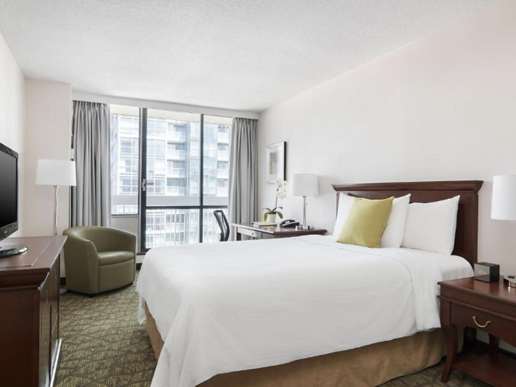 Room in Chelsea Hotel with a bed  flatscreen tv  and desk. 