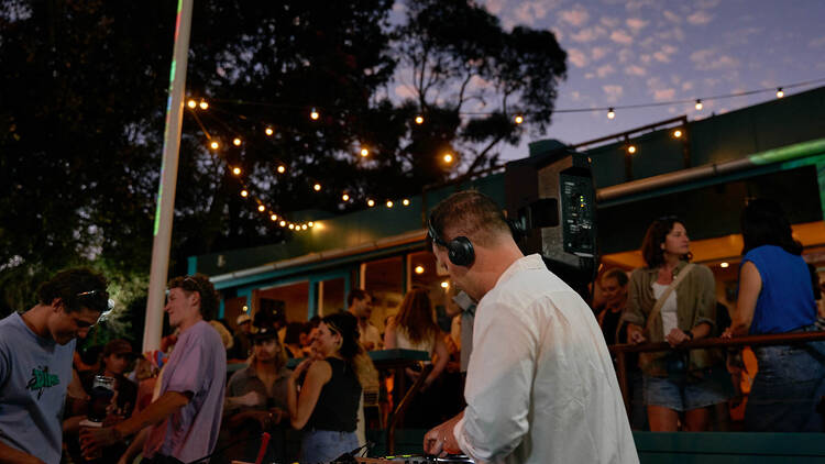 DJ spinning tunes on the decks at The Clam at twilight.