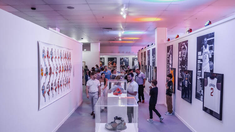 An exhibition with displayed artwork, sneakers and jerseys. 