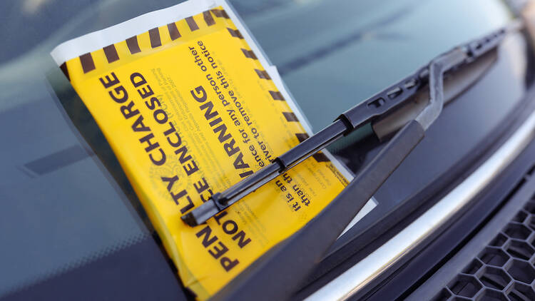 Yellow parking notice in the windshield of a car