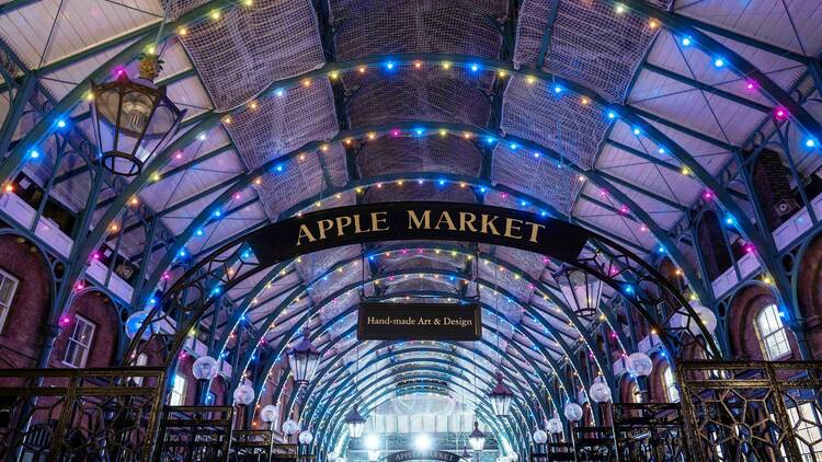 Rainbow coloured lights adorning the arches in Covent Garden's Market Building 