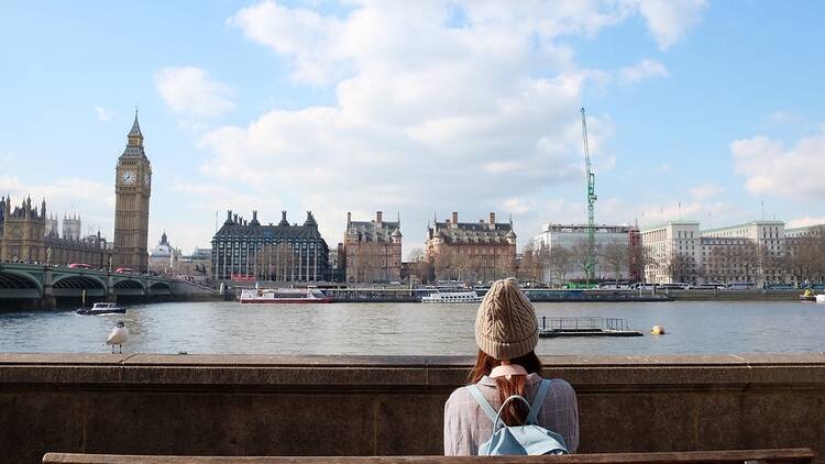 Person on bench in London, next to Big Ben