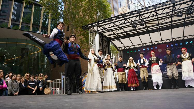 Performers in traditional dress dancing on stage. 